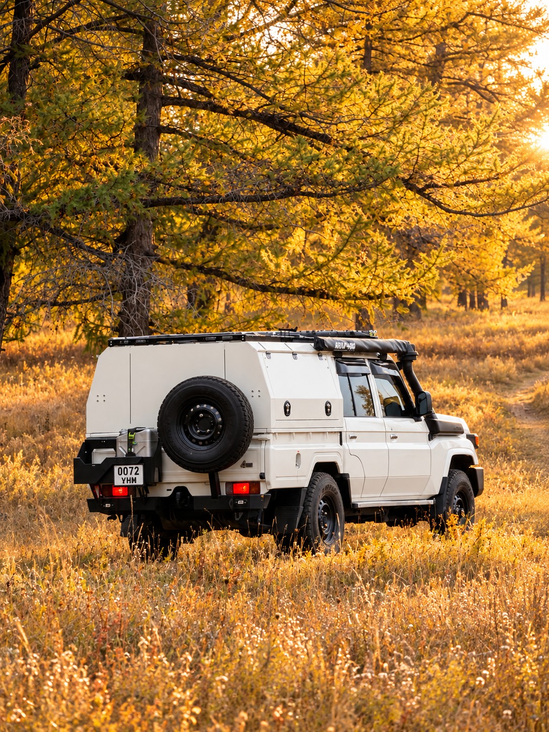 Rear view of the Land Cruiser 79 in a golden autumn forest