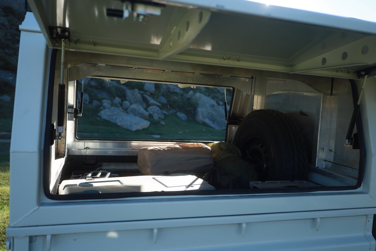 Land Cruiser 79 rear canopy storage area with spare tire and travel gear